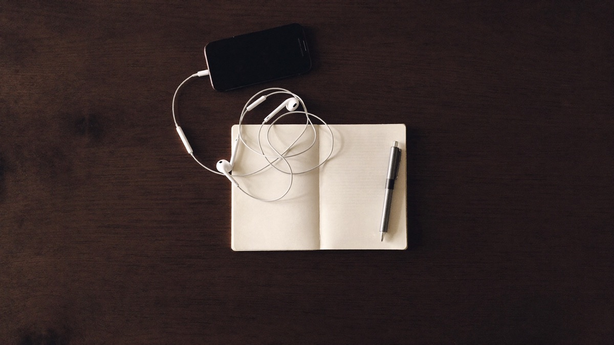 A phone and notebook on a desk in soft daylight